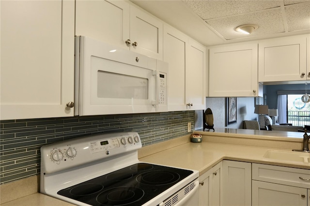 kitchen with white appliances, a sink, white cabinets, light countertops, and tasteful backsplash