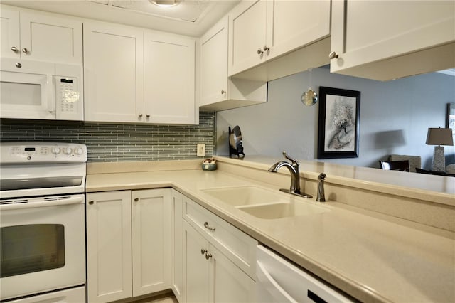 kitchen with light countertops, white appliances, white cabinets, and a sink