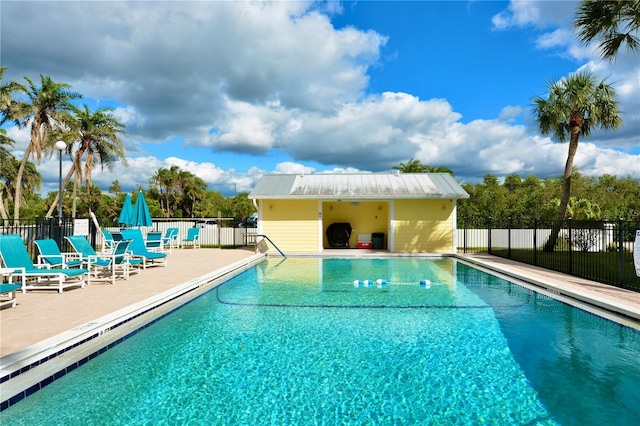 community pool with fence and a patio