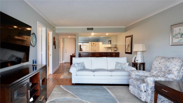 living room featuring ornamental molding, wood finished floors, visible vents, and baseboards