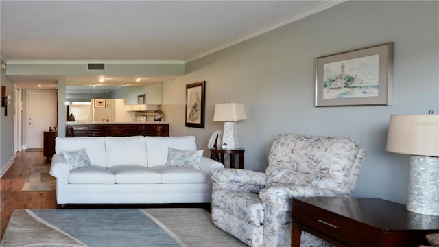 living room featuring ornamental molding, wood finished floors, visible vents, and baseboards