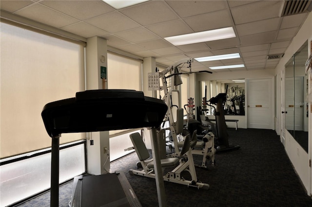 exercise room with a drop ceiling, carpet, and visible vents