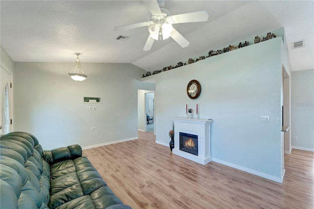 unfurnished living room with light wood finished floors, visible vents, baseboards, ceiling fan, and lofted ceiling