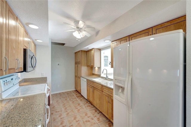 kitchen featuring white appliances, light tile patterned floors, a ceiling fan, baseboards, and a sink