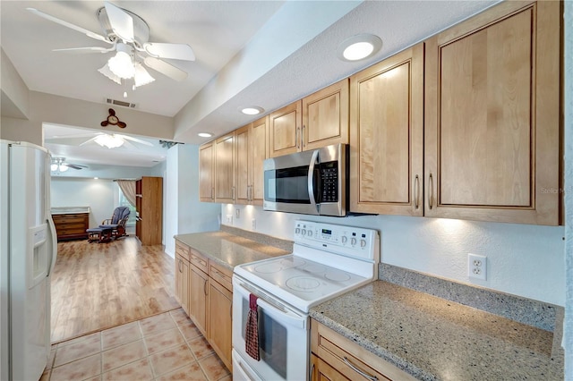 kitchen with white appliances, light tile patterned floors, a ceiling fan, visible vents, and light brown cabinetry