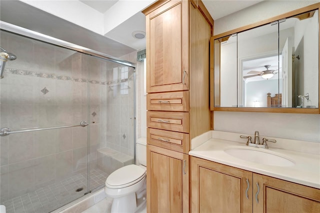 full bathroom with a stall shower, toilet, vanity, and a ceiling fan