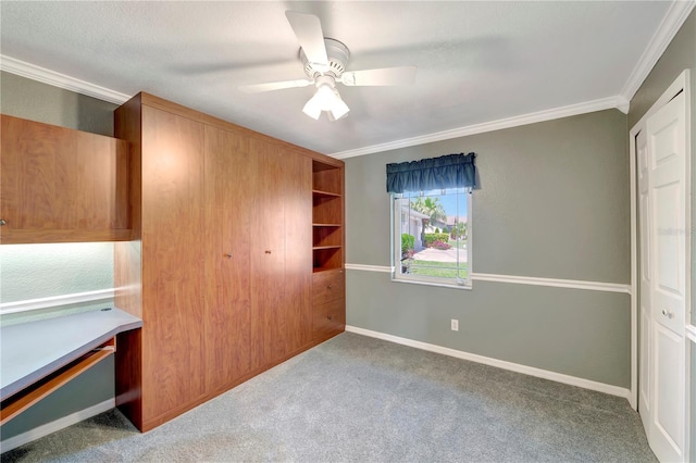 unfurnished bedroom featuring carpet, crown molding, and baseboards