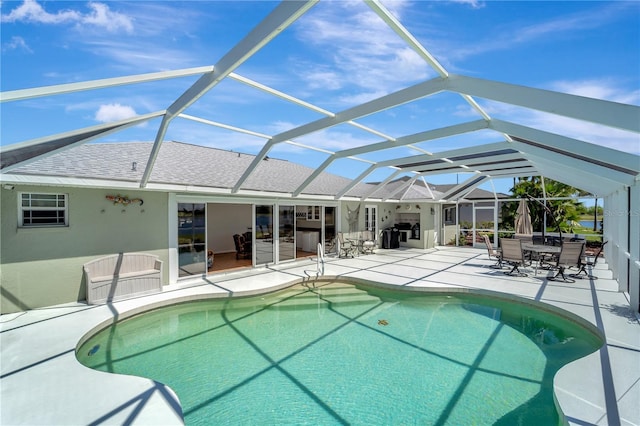 outdoor pool with a patio area and glass enclosure