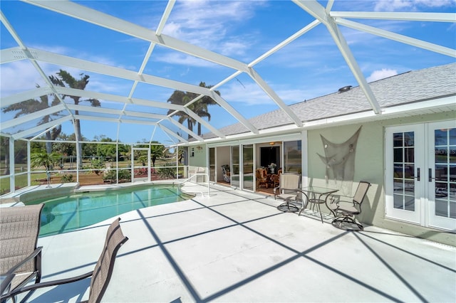 pool with a patio area, glass enclosure, and french doors