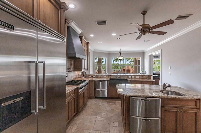 kitchen featuring visible vents, premium range hood, appliances with stainless steel finishes, and a sink