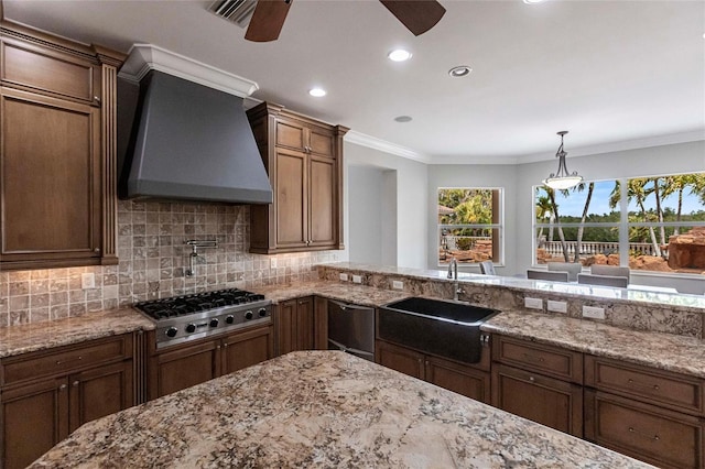 kitchen featuring premium range hood, a sink, tasteful backsplash, stainless steel gas stovetop, and crown molding