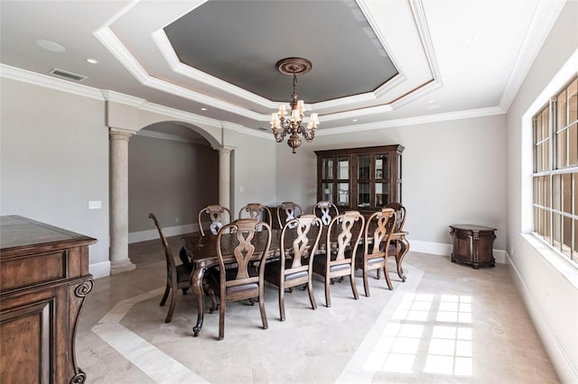 dining room with visible vents, crown molding, a tray ceiling, arched walkways, and ornate columns