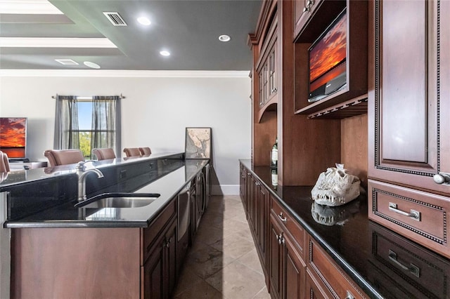 kitchen with a sink, visible vents, ornamental molding, and dark stone counters