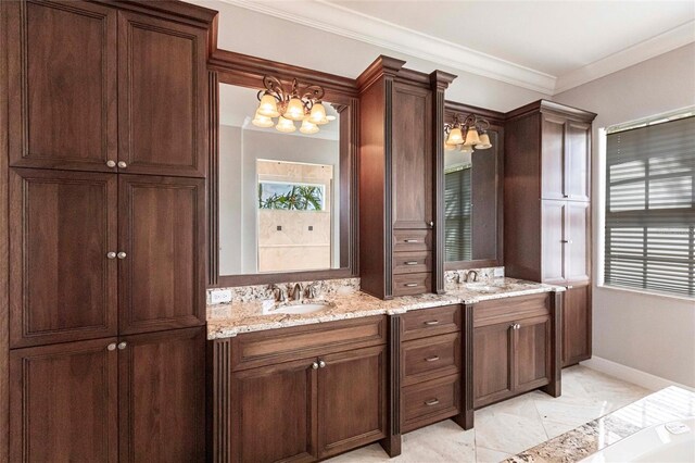 full bath featuring double vanity, crown molding, baseboards, and a sink