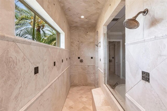 full bathroom featuring a tub, visible vents, ornamental molding, and a tile shower