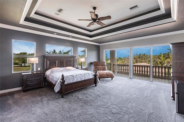 carpeted bedroom featuring a tray ceiling, visible vents, ornamental molding, and access to outside