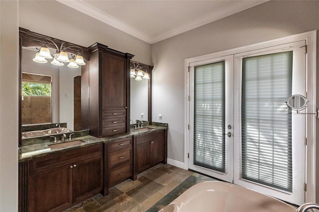 bathroom with double vanity, a freestanding bath, crown molding, and a sink