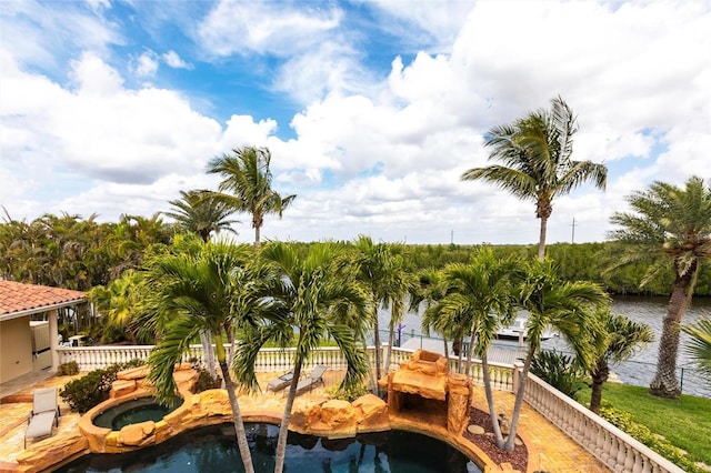 view of pool with a water view, an in ground hot tub, and fence