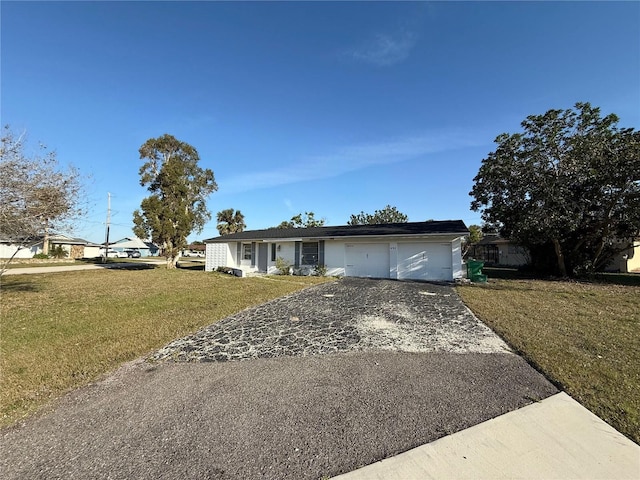 single story home featuring aphalt driveway, an attached garage, and a front lawn