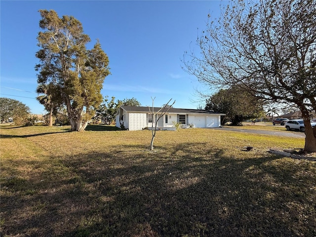 view of front of home with driveway, an attached garage, and a front yard