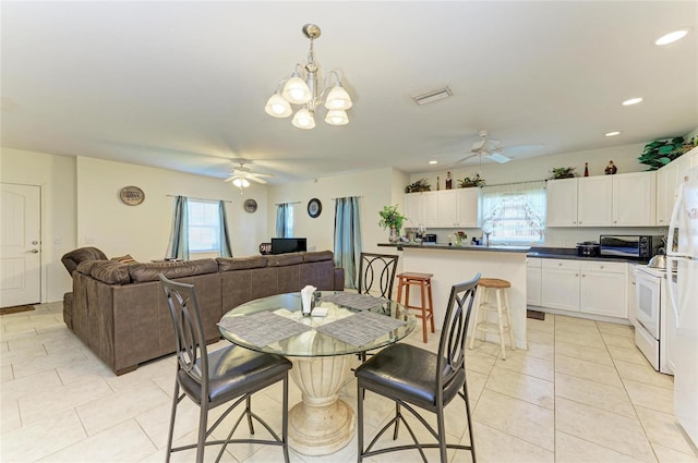 315 Southland Rd, Venice, FL 34293 - dining area featuring a healthy amount of sunlight, light tile patterned flooring, and ceiling fan with notable chandelier