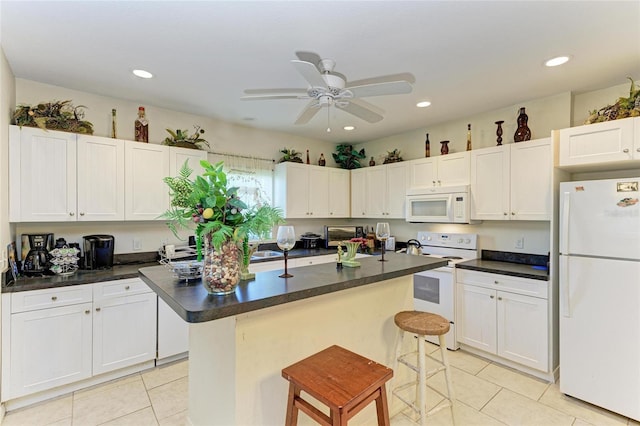 315 Southland Rd, Venice, FL 34293 - kitchen featuring white appliances, white cabinetry, a kitchen breakfast bar, and a center island