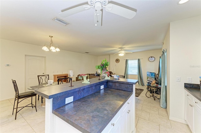 315 Southland Rd, Venice, FL 34293 - kitchen with dark countertops, white cabinetry, visible vents, and hanging light fixtures
