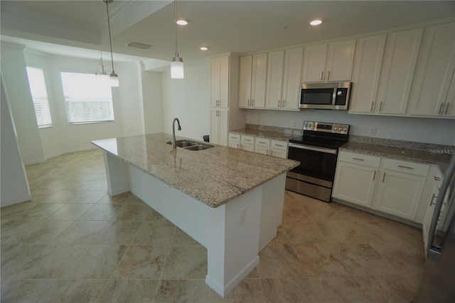 kitchen featuring pendant lighting, a center island with sink, appliances with stainless steel finishes, white cabinets, and a sink