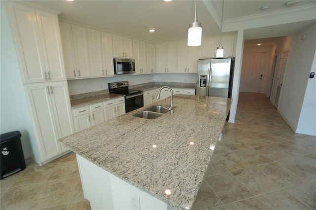 kitchen featuring a center island with sink, stainless steel appliances, hanging light fixtures, white cabinetry, and a sink