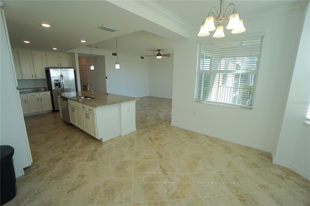 kitchen with decorative light fixtures, appliances with stainless steel finishes, a sink, an island with sink, and dark stone counters