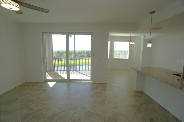 interior space with ceiling fan with notable chandelier, baseboards, visible vents, and crown molding