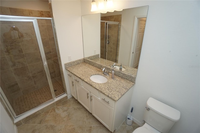 full bathroom featuring vanity, a shower stall, toilet, and tile patterned floors