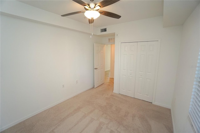 unfurnished bedroom with ceiling fan, light carpet, visible vents, baseboards, and a closet