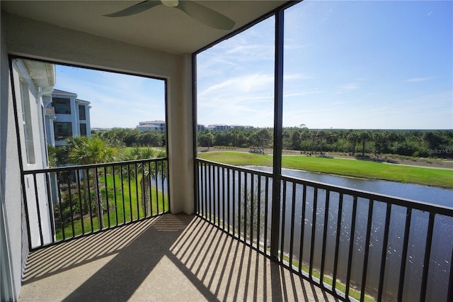 balcony with a water view and a ceiling fan