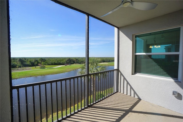 balcony featuring a ceiling fan and a water view