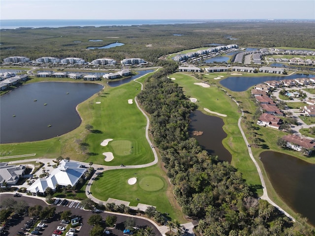 drone / aerial view with golf course view and a water view