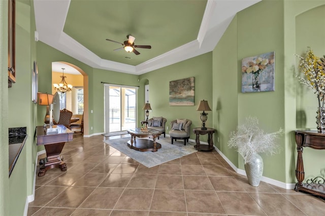 interior space with arched walkways, tile patterned floors, a raised ceiling, baseboards, and ceiling fan with notable chandelier