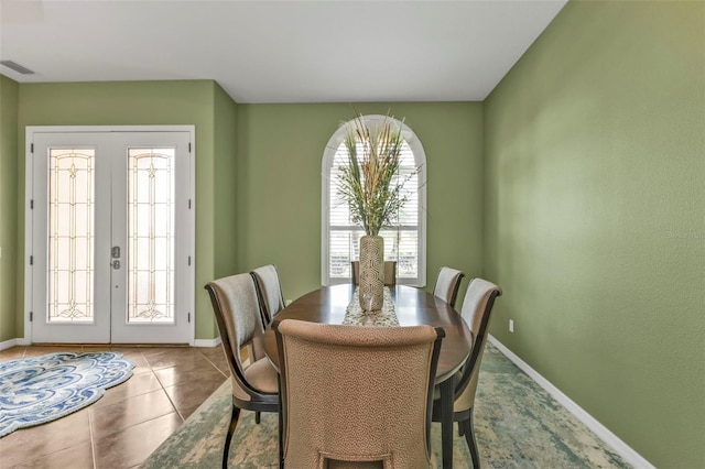 dining space with french doors, visible vents, baseboards, and tile patterned floors