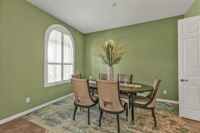 tiled dining area featuring baseboards