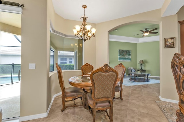 dining room with ceiling fan with notable chandelier, arched walkways, baseboards, and tile patterned floors