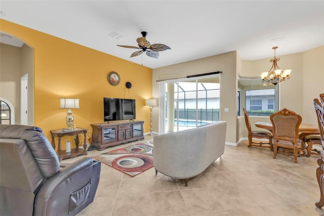 living area with arched walkways, light tile patterned floors, visible vents, ceiling fan, and baseboards