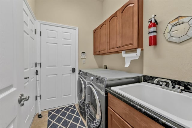 clothes washing area with cabinet space, light tile patterned flooring, a sink, and washing machine and clothes dryer