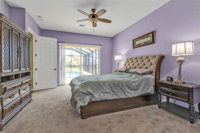 carpeted bedroom with access to exterior, visible vents, and a ceiling fan