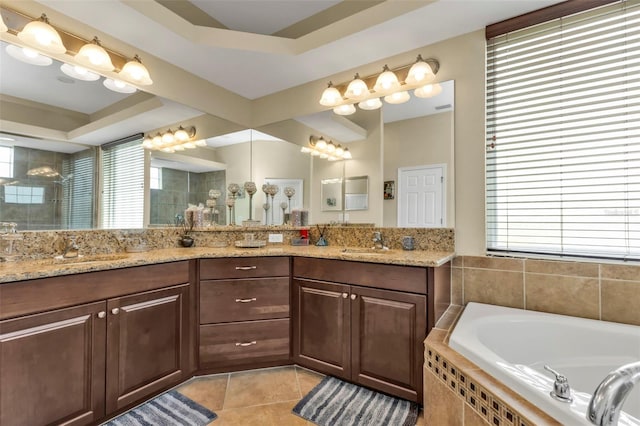 full bath featuring plenty of natural light, tile patterned flooring, a sink, and a garden tub