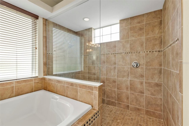 bathroom with a tile shower and a garden tub