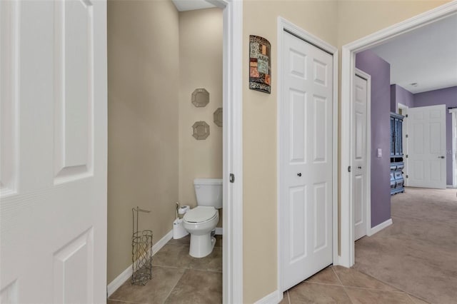 bathroom with toilet, baseboards, and tile patterned floors