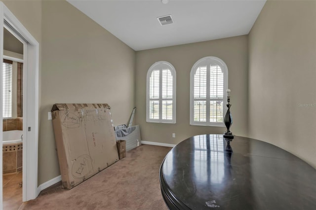 dining room featuring visible vents, light carpet, and baseboards