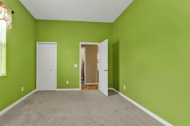 unfurnished bedroom featuring a closet, carpet flooring, and baseboards