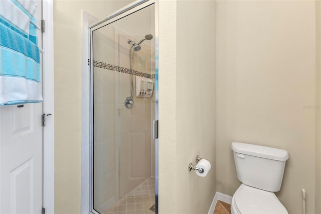 bathroom featuring toilet and a stall shower