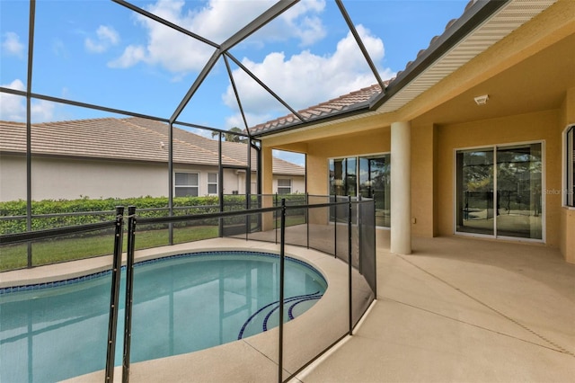 outdoor pool with glass enclosure and a patio area